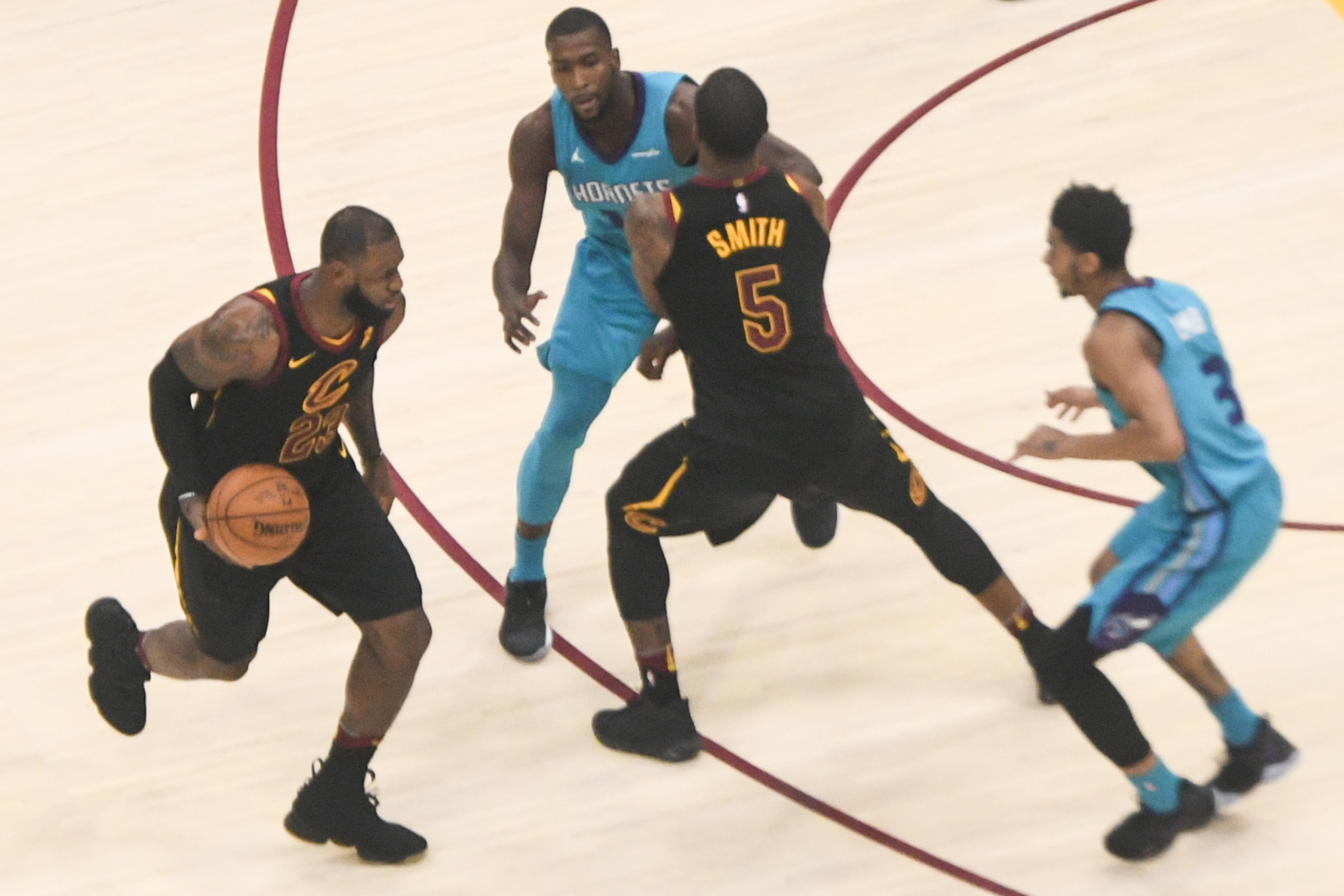 Uma fotografia mostra LeBron James driblando uma bola de basquete durante um jogo de basquete