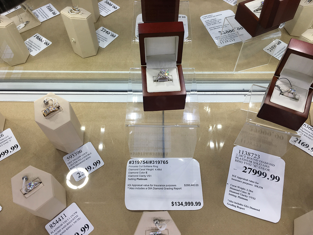 Une photographie montre une vitrine à bijoux remplie de bagues en diamant. Certaines bagues coûtent plus de 130 000 dollars.
