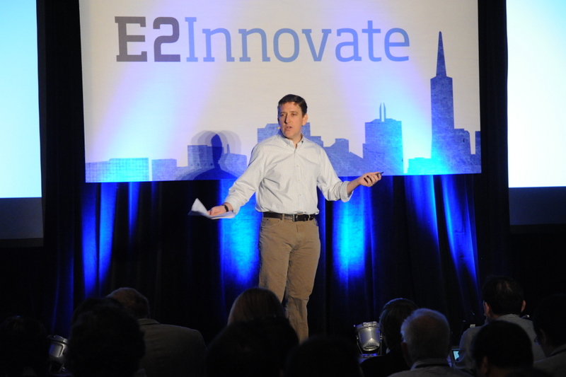 一张照片显示本·弗里德在舞台上，身后有一面写着 “E 2，创新” 的横幅。