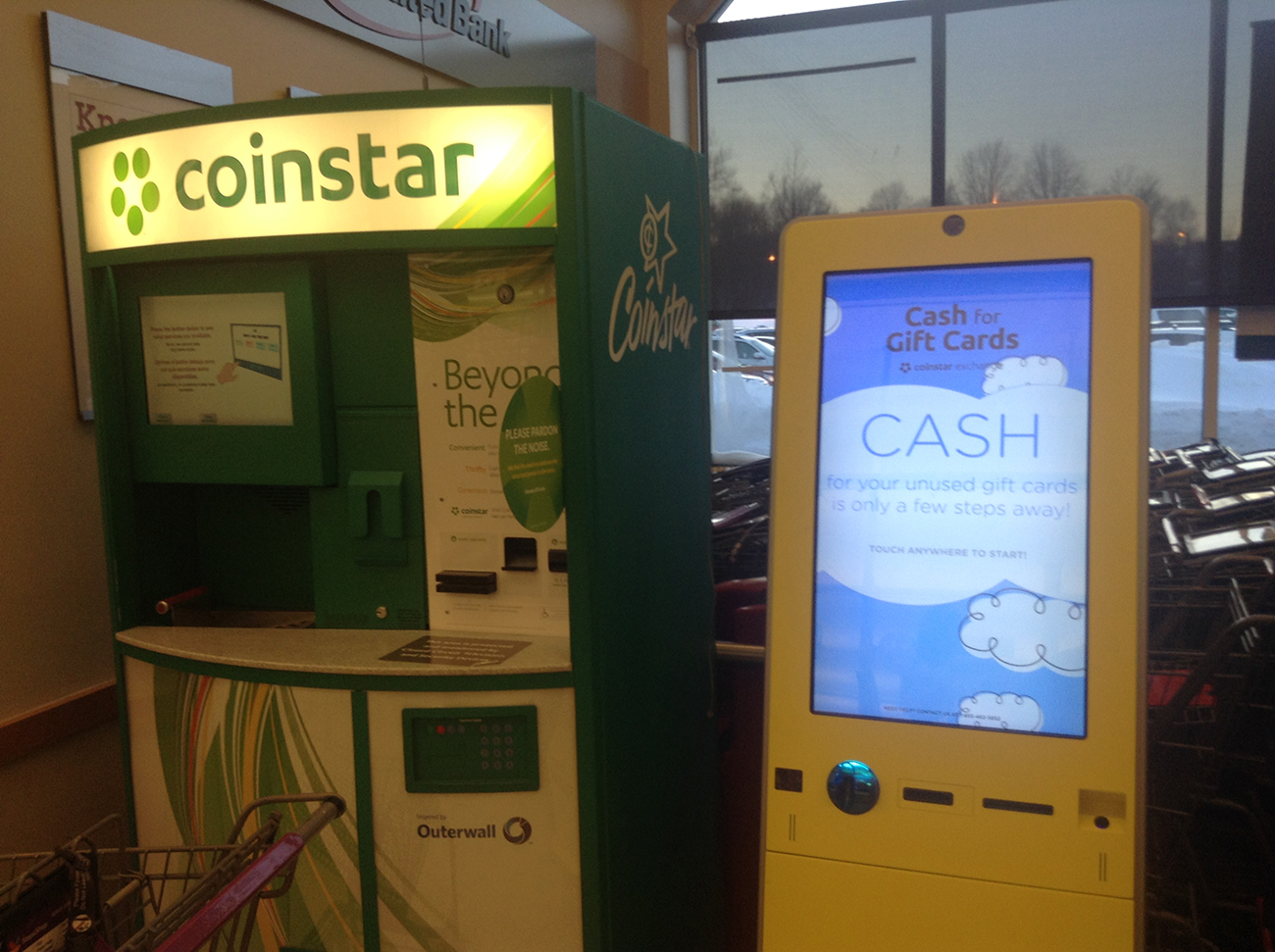 A fotografia mostra uma máquina de estrela-moeda ao lado de uma máquina de dinheiro para cartões-presente.