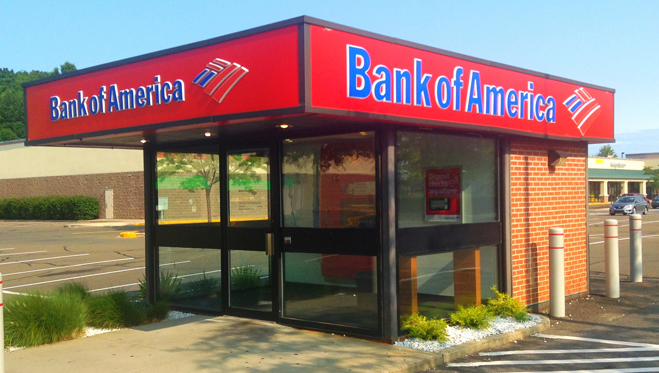 Une photographie montre un A T M de Bank of America à l'intérieur d'un grand kiosque sur un parking