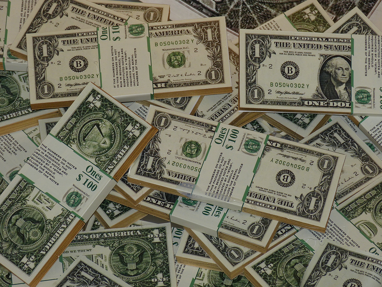 一张照片显示美元钞票捆绑并包装成100美元的金额。