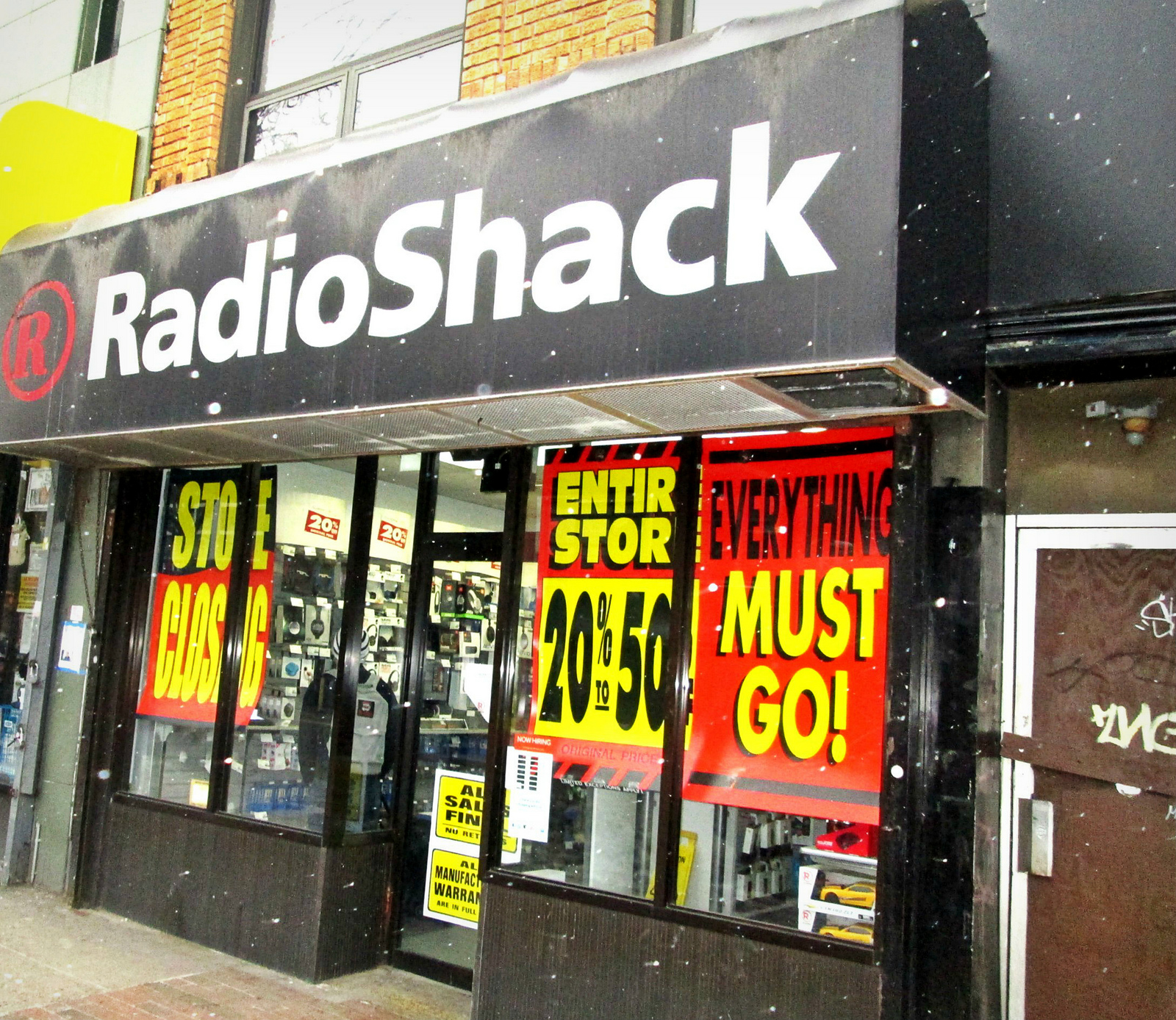 Foto de la tienda Radio Shack saliendo del negocio. Escaparate cubierto con letreros que decían: “¡Todo debe irse!”