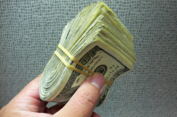 Photo of a large bundle of hundred-dollar bills.