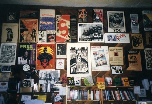 Bound Together Bookstore, a wall full of alt political posters and bookshelves.