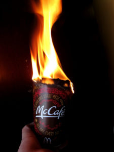 Cup of "McCafe" coffee, shown with a flame burning from the top of the cup.
