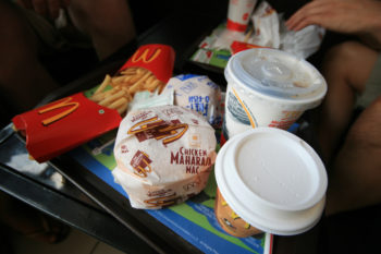 Photo of a plastic food tray with McDonald's fries, two drinks, a regular burger, and a chicken "Maharaja Mac."
