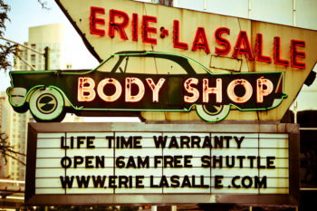 Photo of neon sign for Erie LaSalle Body Shop. The marquee reads, "Life time warranty, open 6am, free shuttle, www.erielasalle.com"