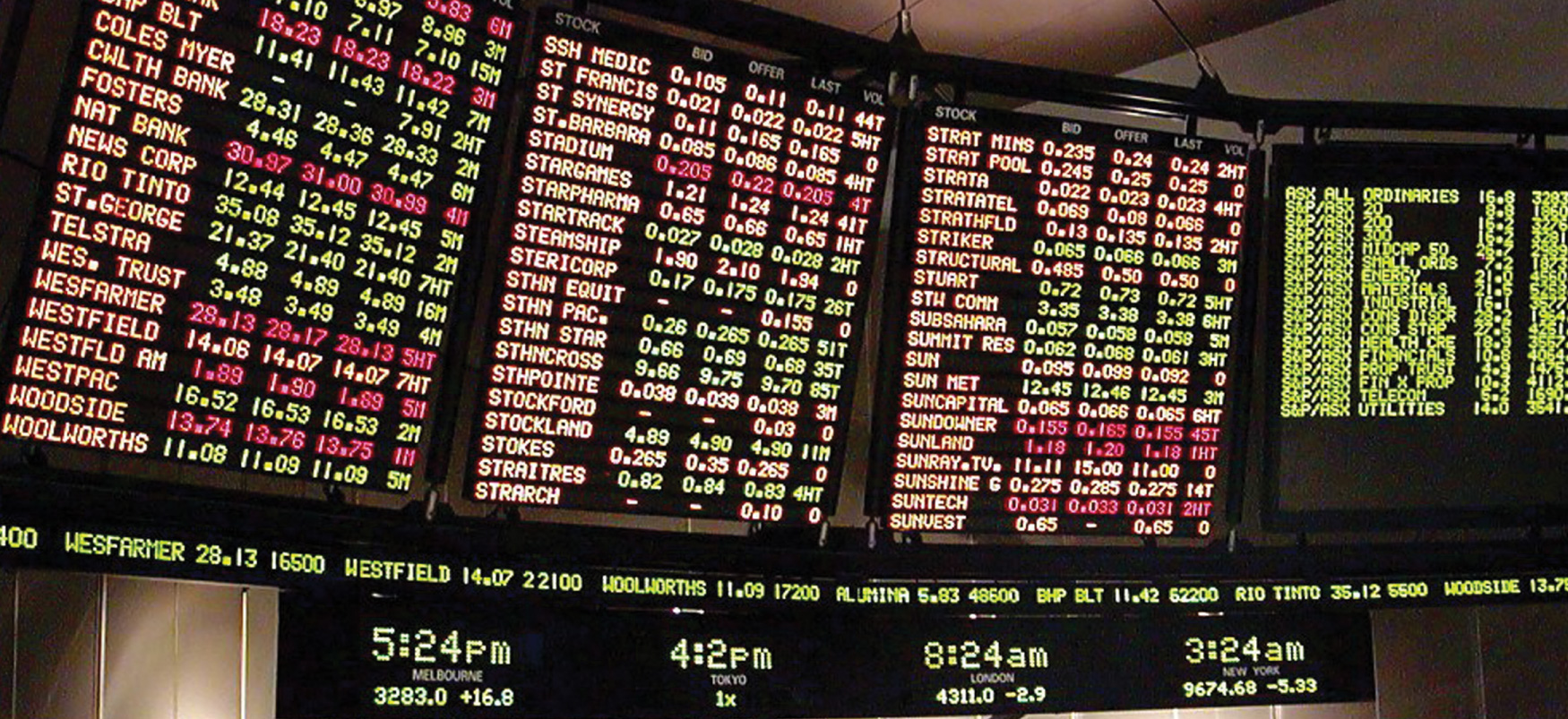 Electronic boards showing live ticker updates of the shares of companies listed on a stock market.