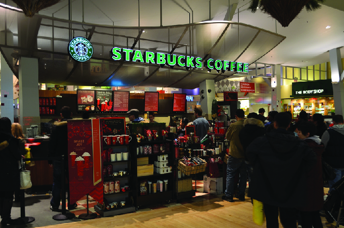 Una imagen del interior de una tienda Starbucks mostrando estantes de artículos a la venta.