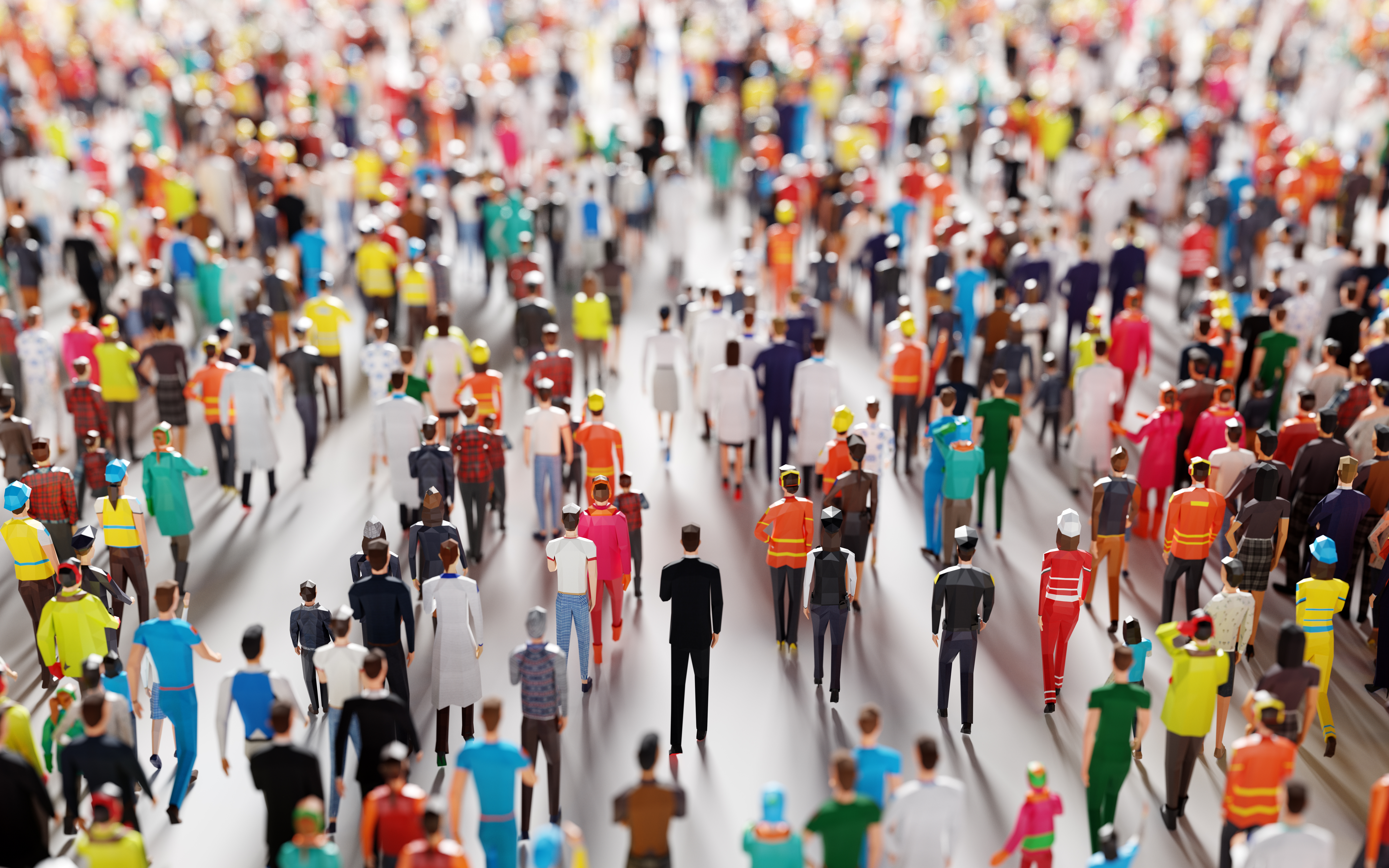 A large crowd of diverse miniature figures in various colorful outfits, viewed from above, walking on a pavement.