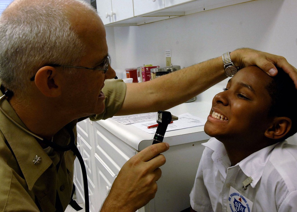A pediatrician examining a patient's teeth