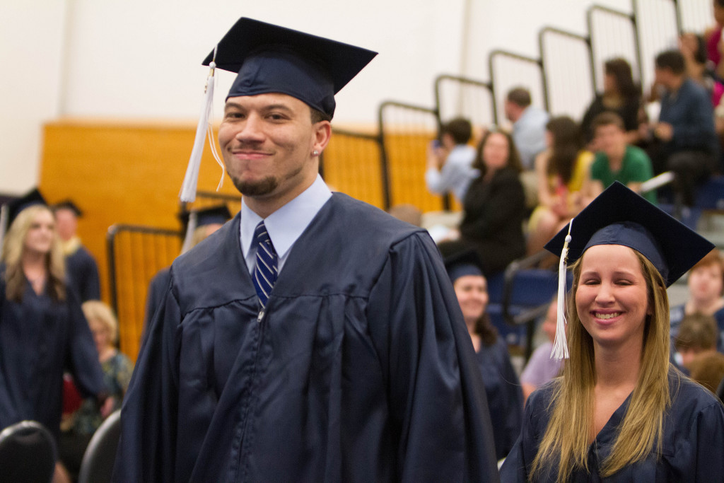 Foto de dos alumnos vistiendo gorras y batas, en la graduación.