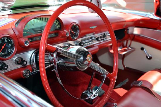Photo of the steering wheel and dashboard of a classic automobile.