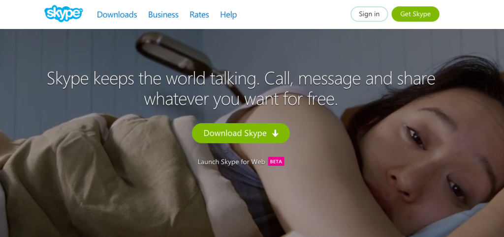 Una captura de pantalla del sitio web de Skype. Por encima de una foto grande de una mujer triste hay un botón que dice Descargar Skype y las palabras Skype mantiene al mundo hablando. Llama, envía mensajes y comparte lo que quieras de forma gratuita.