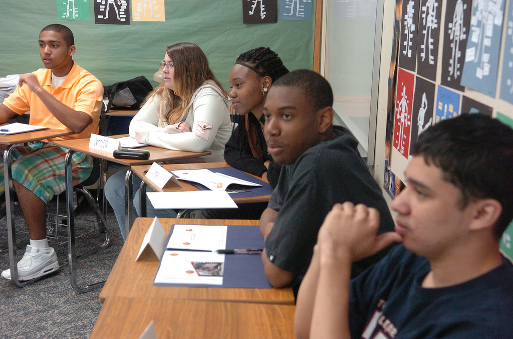 Un grupo de alumnos en los escritorios escuchando.