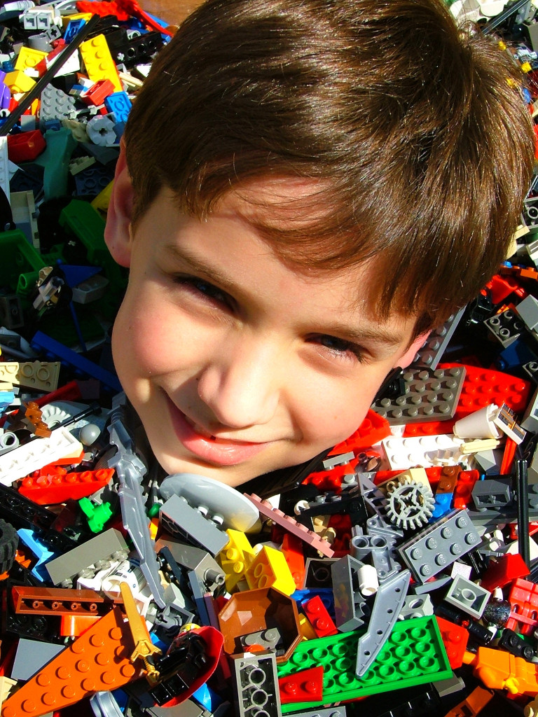 Una foto de un joven literalmente hasta el cuello en LEGOs.