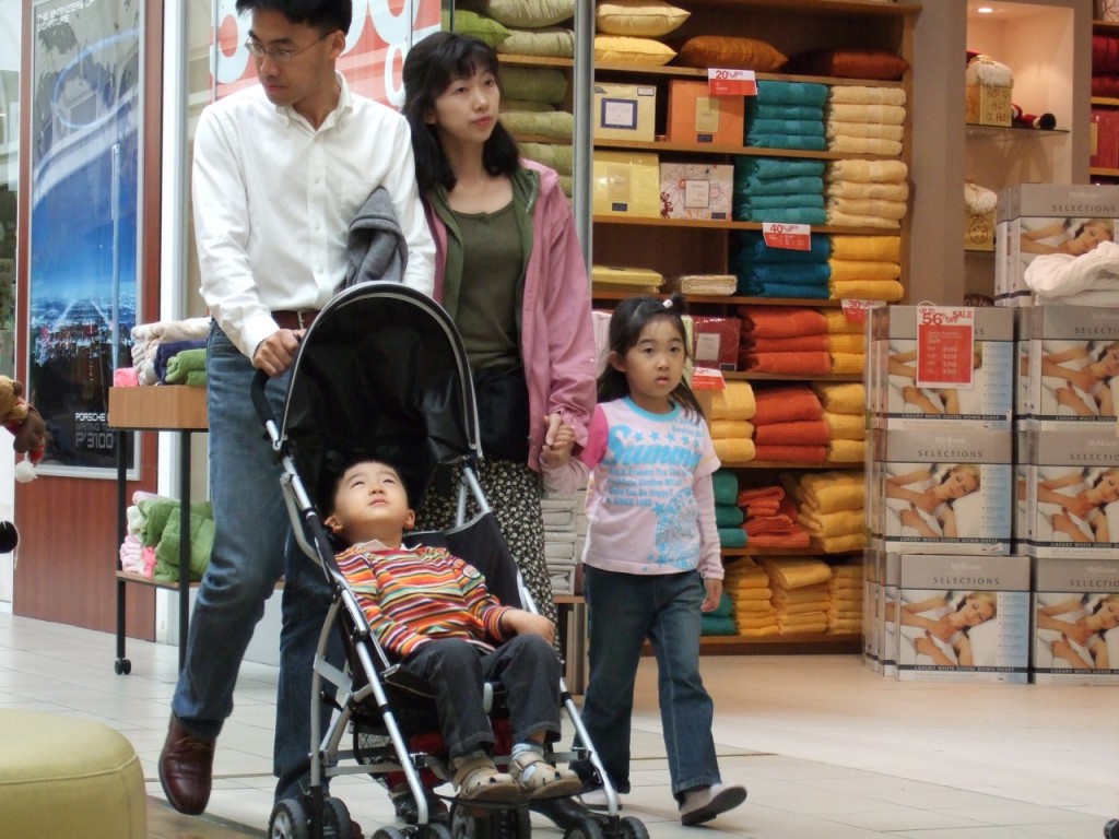 Una joven familia asiática compra juntos en una tienda de artículos para el hogar.